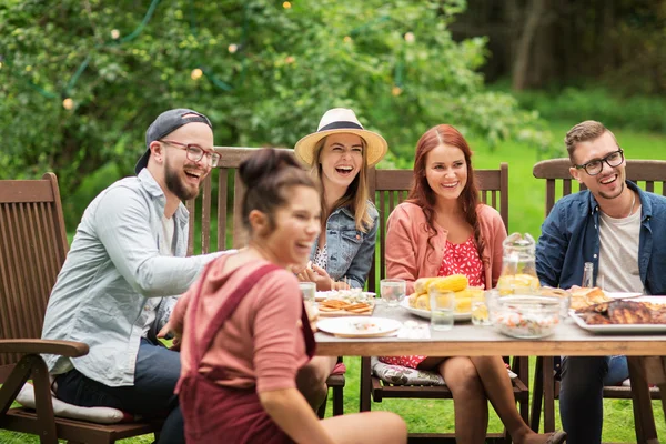 Happy vrienden hebben van diner bij zomer tuinfeest — Stockfoto