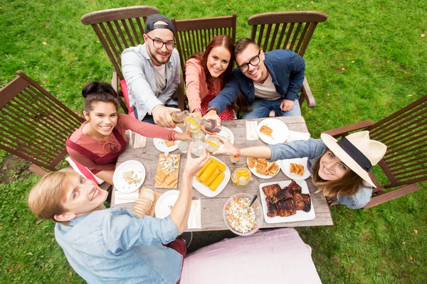 Happy vrienden hebben van diner bij zomer tuinfeest — Stockfoto