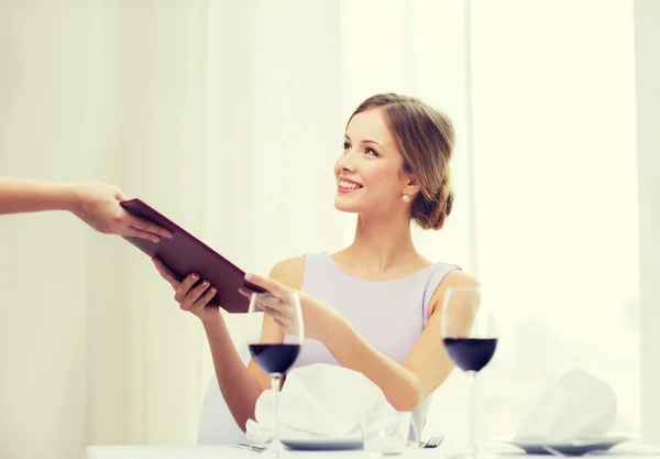 Mujer sonriente dando menú al camarero en el restaurante — Foto de Stock