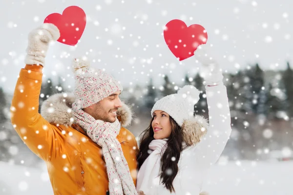 Coppia felice con cuori rossi sul paesaggio invernale — Foto Stock