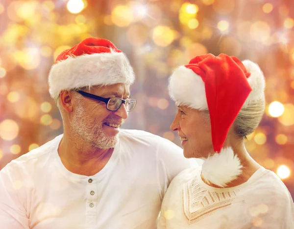 Happy senior couple in santa helper hats — Stock Photo, Image