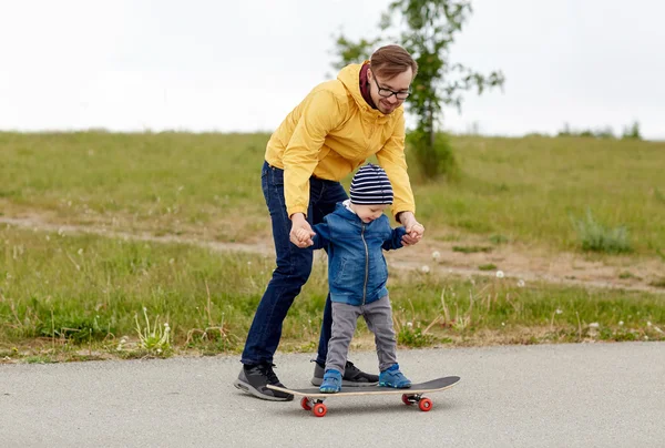 Šťastný otec a malého syna na skateboard — Stock fotografie