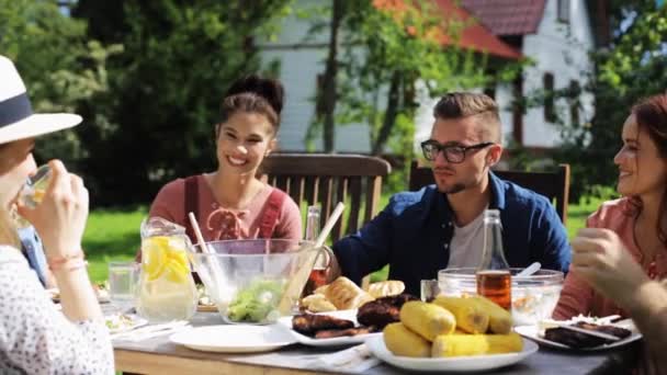 Glückliche Freunde beim Abendessen bei sommerlicher Gartenparty — Stockvideo