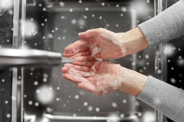 Kvinna tvätta händerna med tvål i köket — Stockfoto