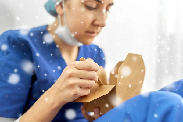 Trauriger Arzt oder Krankenschwester isst Essen zum Mitnehmen aus Schachtel — Stockfoto