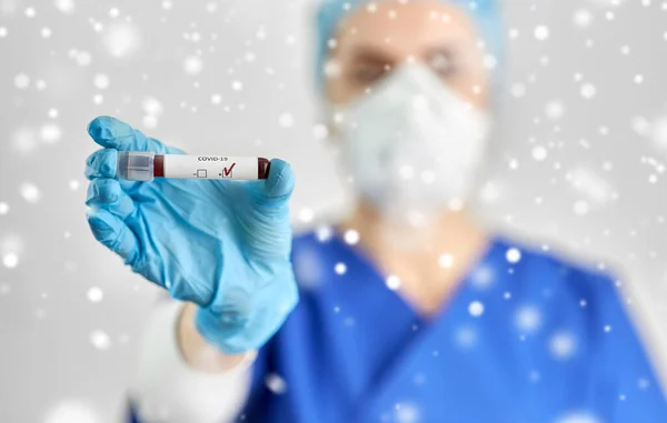 Médico sosteniendo vaso de precipitados con análisis de sangre de coronavirus —  Fotos de Stock