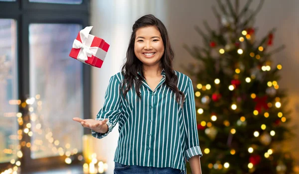 Happy asian woman with christmas gift at home — Stock Photo, Image