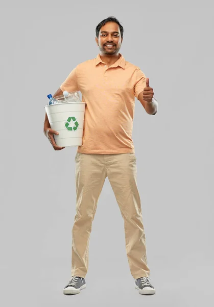 Glimlachende jonge indiaanse man sorteren plastic afval — Stockfoto