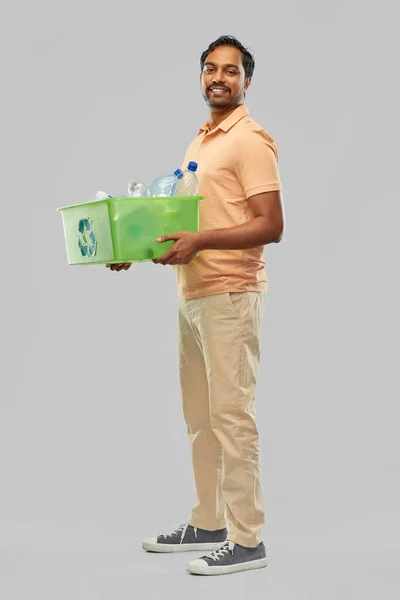 Sorrindo jovem índio homem triagem de resíduos plásticos — Fotografia de Stock