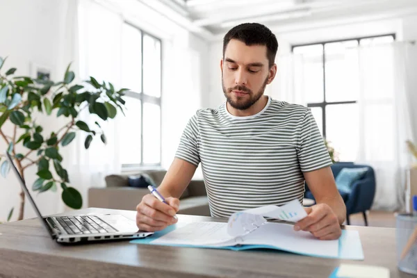 Uomo con documenti e laptop che lavora a casa ufficio — Foto Stock