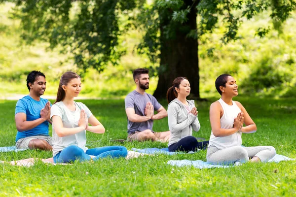 Groupe de personnes heureuses faisant du yoga au parc d'été — Photo