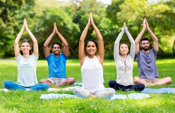 Groep gelukkige mensen die yoga doen in het zomerpark — Stockfoto