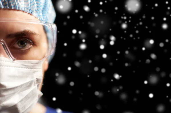 Female doctor or nurse in goggles and face mask — Stock Photo, Image