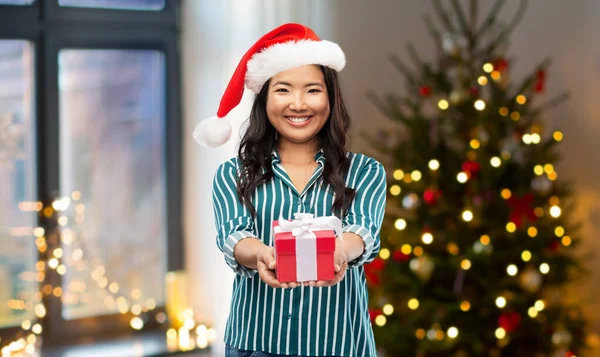 Glad asiatisk kvinna med julklapp hemma — Stockfoto