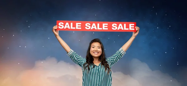 Счастливая улыбающаяся молодая азиатка со знаменем продажи — стоковое фото