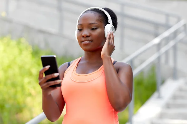 拥有耳机和电话的非洲裔美国女人 — 图库照片