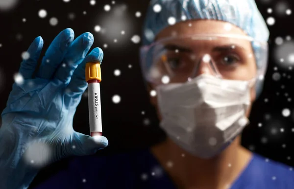 Médico segurando copo com teste de sangue vírus — Fotografia de Stock