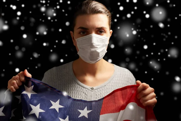 Sjuk kvinna i ansiktsmask håller flagga av Amerika — Stockfoto