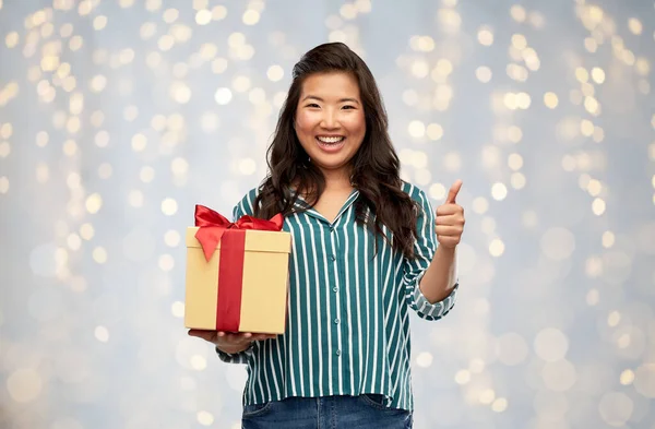 Szczęśliwy Azji kobieta z prezent pudełko pokazując kciuki w górę — Zdjęcie stockowe