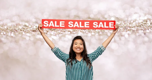 Счастливая улыбающаяся молодая азиатка со знаменем продажи — стоковое фото