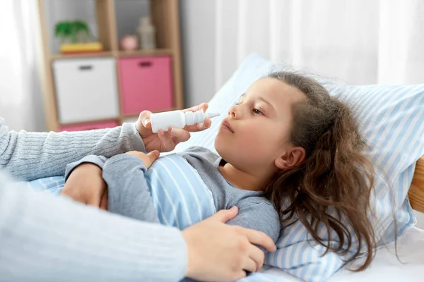 Madre con spray nasal trata hija enferma —  Fotos de Stock