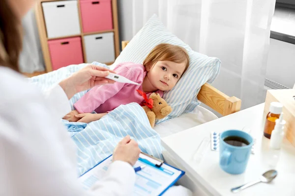 Médecin mesure la température des filles malades — Photo