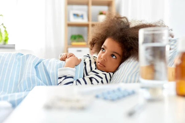 Ziek Afrikaans amerikaans meisje liggend in bed thuis — Stockfoto