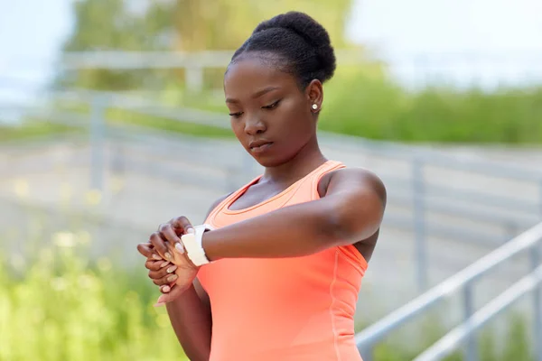 Afrikanska kvinna med smart klocka gör sport — Stockfoto