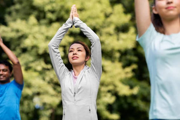 Grupp människor som gör yoga på sommarparken — Stockfoto