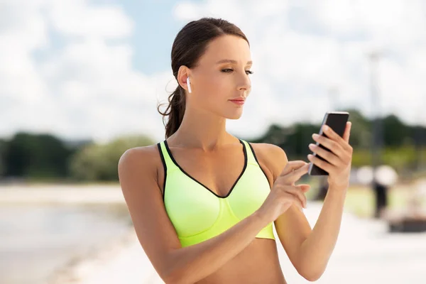 Frau mit Kopfhörer und Smartphone beim Sport — Stockfoto