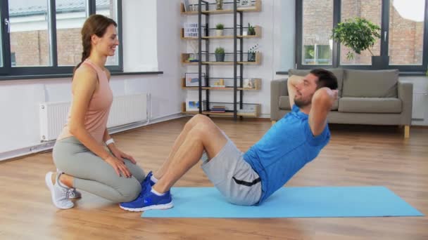 Uomo con personal trainer fare sit up a casa — Video Stock