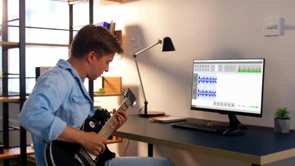 Hombre tocando la guitarra y grabando música en casa — Vídeo de stock