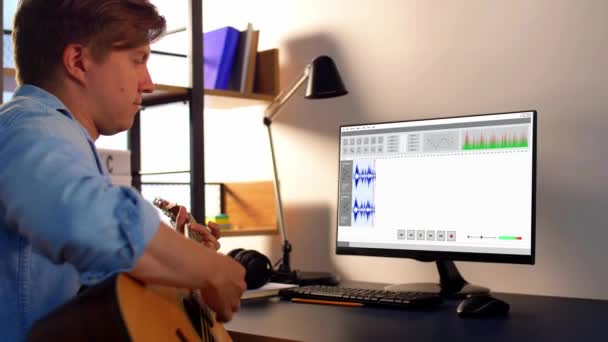 Hombre tocando la guitarra y grabando música en casa — Vídeos de Stock