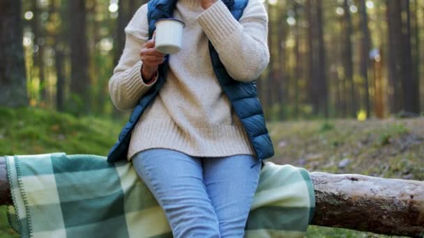 Mujer mayor bebiendo té y comiendo pastel en el bosque — Vídeos de Stock