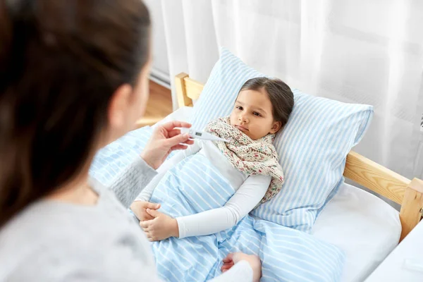 Mãe medir a temperatura da filha doente — Fotografia de Stock