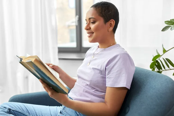 Mujer afroamericana feliz leyendo libro en casa — Foto de Stock