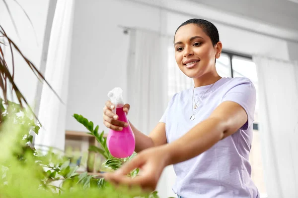 Donna spruzzando pianta d'appartamento con acqua a casa — Foto Stock