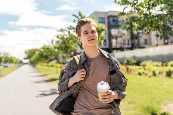 Jovem com mochila bebendo café na cidade — Fotografia de Stock