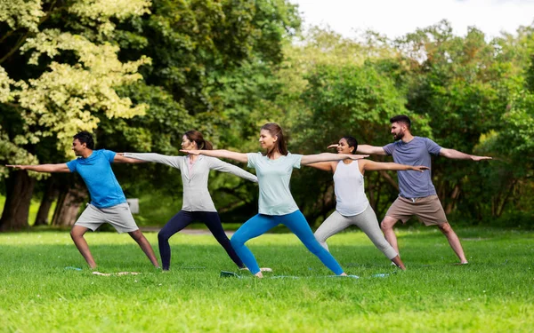 Groep mensen die yoga doen in het zomerpark — Stockfoto