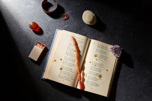 Волшебная книга, восковая свеча, спички и драгоценные камни — стоковое фото