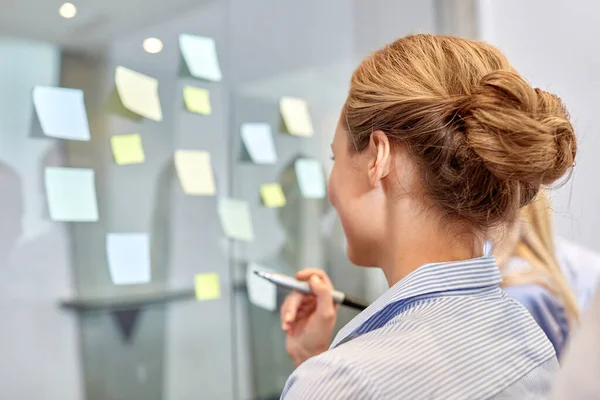 Geschäftsteam mit klebrigen Zetteln auf Glas im Büro — Stockfoto