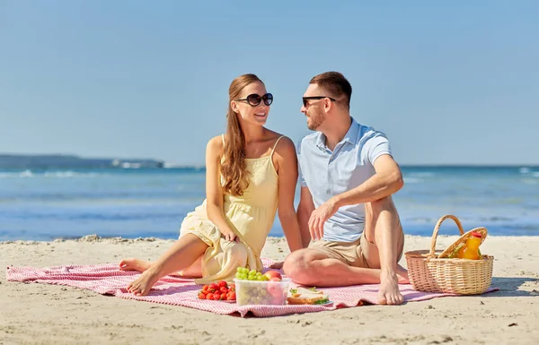 Feliz pareja teniendo picnic en la playa de verano — Foto de Stock