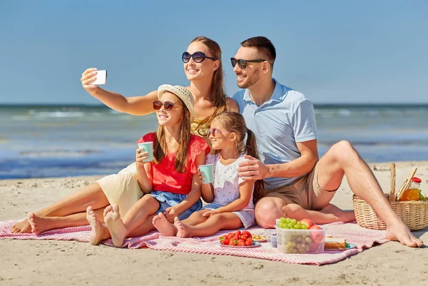 Familia feliz tomando selfie en la playa de verano —  Fotos de Stock