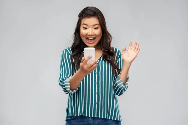 스마트폰으로 손을 흔드는 행복 한 동양 여성 — 스톡 사진