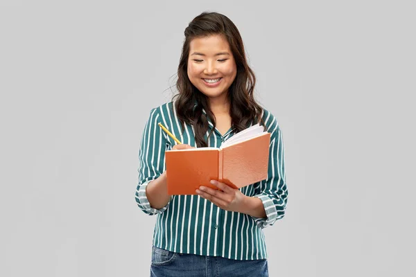 Felice asiatico studente donna con diario e matita — Foto Stock