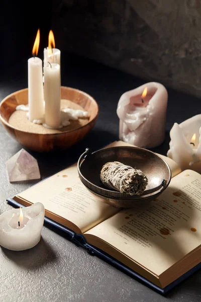 Libro magico, salvia, candele accese e bastone rituale — Foto Stock