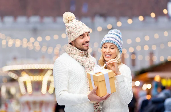Glimlachend paar in winterkleding met geschenkdoos — Stockfoto