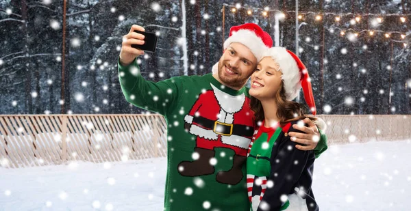 Gelukkig paar in kerst truien het nemen van selfie — Stockfoto