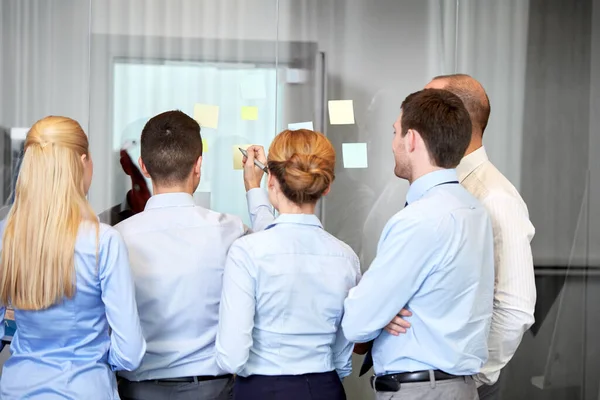 Business team with sticky notes on glass at office — Stock Photo, Image
