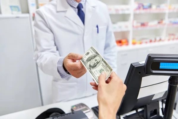 Lékárník bere peníze od zákazníka v lékárně — Stock fotografie